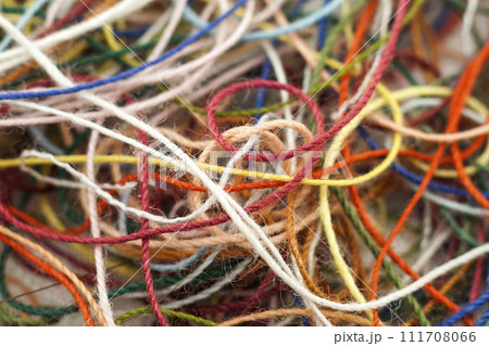 Multi-colored tangled colorful needlecraft silk thread rope. Macro shot. Abstract colors background Multi-colored tangled colorful needlecraft silk thread rope. Macro shot. Abstract colors background 111708066