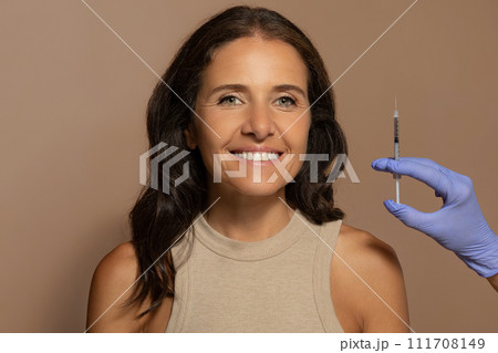 Glad caucasian old lady, enjoy anti-wrinkle treatment, beautician makes injection 111708149