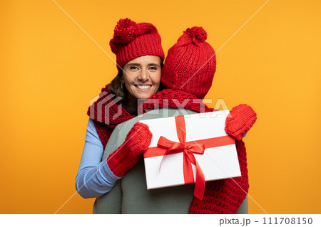Cheerful senior european wife in hat hug husband at winter, gift box present Cheerful senior european wife in hat hug husband at winter, gift box present 111708150