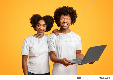 Smiling cool african american couple using computer on background Smiling cool african american couple using computer on background 111708384