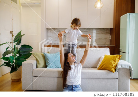 Happy Young Mother Playing With Her Toddler Daughter At Home Happy Young Mother Playing With Her Toddler Daughter At Home 111708385