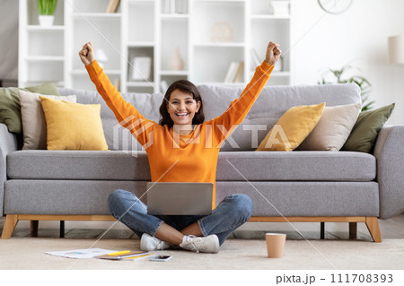 Excited young indian woman with laptop raising hands up Excited young indian woman with laptop raising hands up 111708393