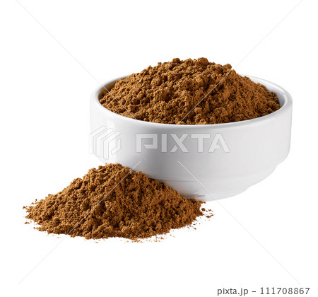 cinnamon powder spilled out of a ceramic bowl isolated on a white background. 111708867