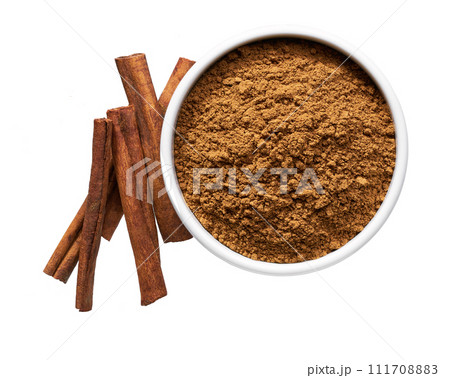 cinnamon sticks and  ceramic bowl with cinnamon powder isolated on a white background, top view. 111708883