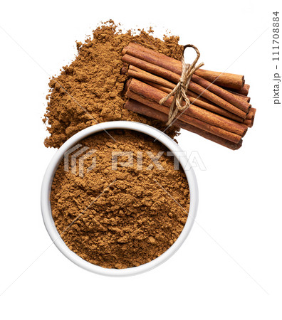 cinnamon sticks and ceramic bowl with cinnamon powder isolated on a white background, top view. cinnamon sticks and ceramic bowl with cinnamon powder isolated on a white background, top view. 111708884