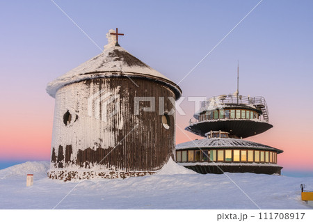 Wooden Roman catholic chapel and disc shaped meteorological observatory in snezka, mountain on the border between Czech Republic and Poland, winter, sunrise time. 111708917