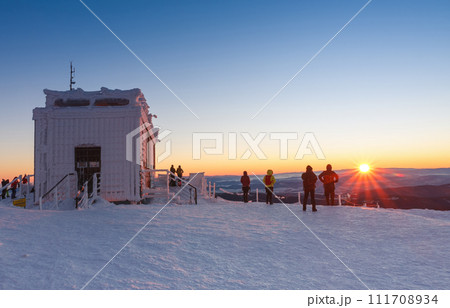 Tourists watching sunrise around wooden building of new post office with souvenirs and postcards in snezka, mountain on the border between Czech Republic and Poland, winter. 111708934