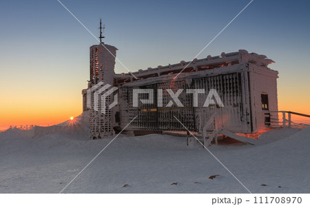 Wooden building of new post office with souvenirs and postcards in snezka, mountain on the border between Czech Republic and Poland, winter, sunrise time. 111708970