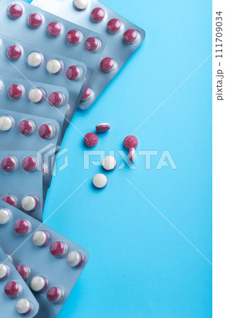 Close up of a colorful pills bicolor pills wrapped in the blister. Three tablets out of the blister. Close up of a colorful pills bicolor pills wrapped in the blister. Three tablets out of the blister. 111709034