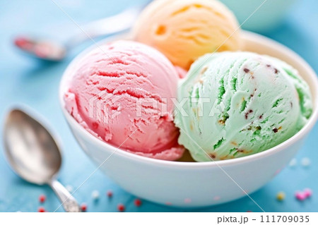 Scoops of ice cream in a bowl on a blue background Scoops of ice cream in a bowl on a blue background 111709035