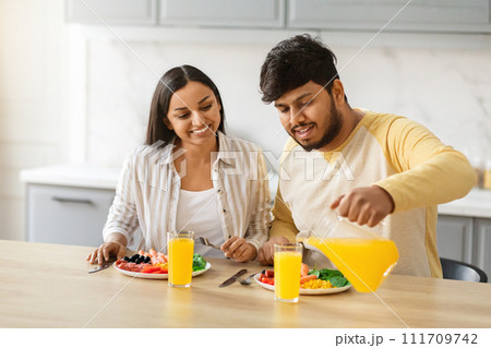 Happy loving young indian couple have breakfast together at home 111709742
