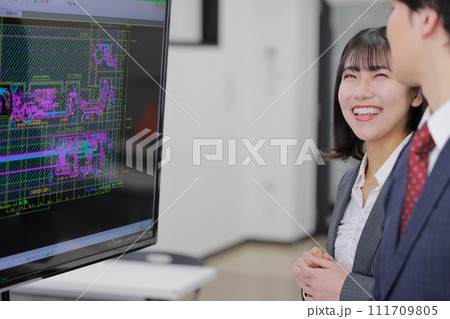 CAD図面を見て打ち合わせする男女_5 111709805