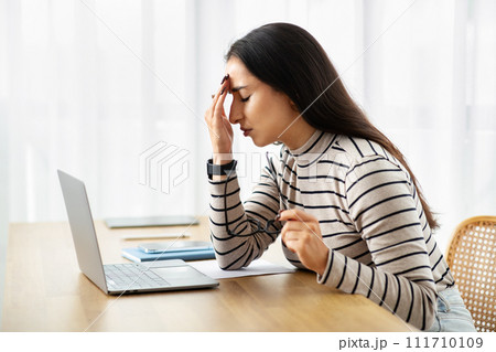 Sad young arab woman work at computer, suffer from migraine, health problems, pain and headache Sad young arab woman work at computer, suffer from migraine, health problems, pain and headache 111710109
