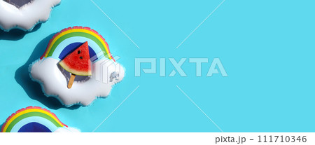 Watermelon slice popsicle on inflatable ring. Summer background concept Watermelon slice popsicle on inflatable ring. Summer background concept 111710346
