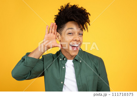 Curious interested african american man holding hand near ear Curious interested african american man holding hand near ear 111710375