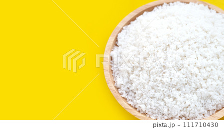Flower of salt in wooden plate on yellow background. Flower of salt in wooden plate on yellow background. 111710430