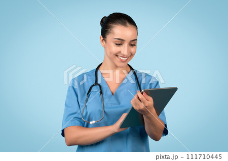 Smiling young woman nurse using a tablet Smiling young woman nurse using a tablet 111710445