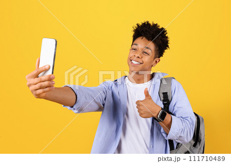 Happy black male student taking selfie with thumbs up Happy black male student taking selfie with thumbs up 111710489