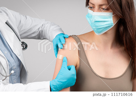 Young black doctor puts plaster on hand after injection to pregnant woman patient at pregnancy Young black doctor puts plaster on hand after injection to pregnant woman patient at pregnancy 111710616