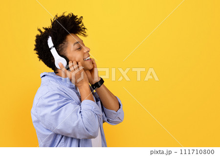 Happy black man enjoying music on headphones Happy black man enjoying music on headphones 111710800