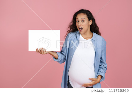 Shocked pregnant woman showing white blank placard for advertisement 111710869
