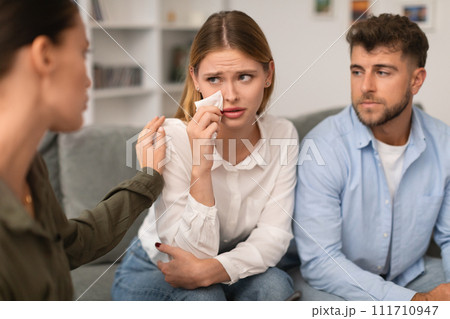 Therapist gently comforts crying woman during couples therapy session indoor Therapist gently comforts crying woman during couples therapy session indoor 111710947
