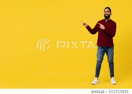 Cool positive young eastern guy pointing at blank space Cool positive young eastern guy pointing at blank space 111711031