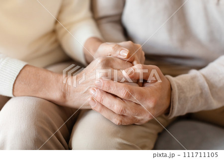 Old middle aged people holding hands close up view Old middle aged people holding hands close up view 111711105
