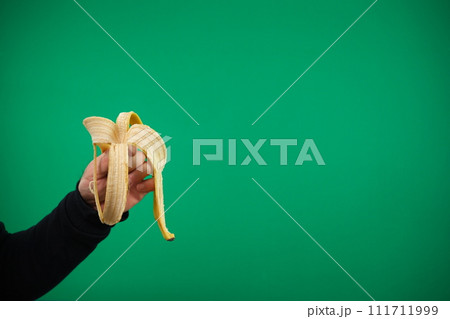 Skin from banana in the male hand, isolated. advertising Green background chromakey banana skin hand Skin from banana in the male hand, isolated. advertising Green background chromakey banana skin hand 111711999