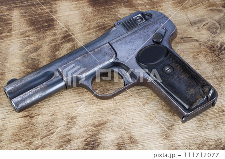 antique rusty handgun on wooden table 111712077