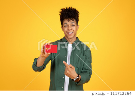 Cheerful young black guy showing bank card 111712264