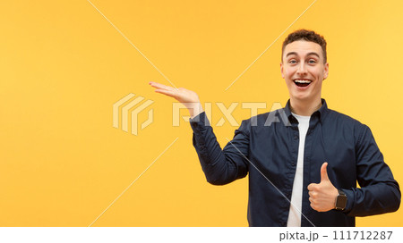 Excited young guy pointing at blank space 111712287