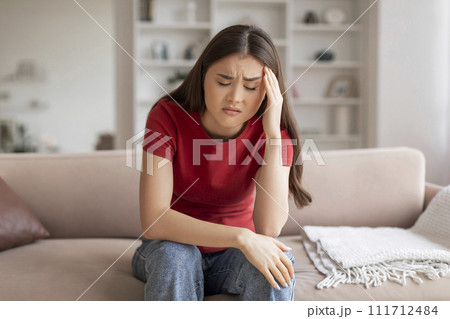Anxious young asian woman suffering signs of headache or stress 111712484