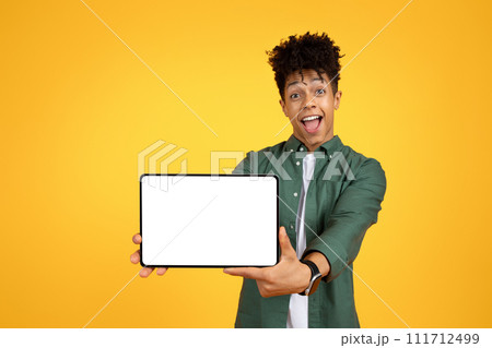 Excited african american guy showing tablet with white screen 111712499
