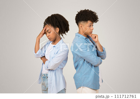 Upset young African American woman and man standing back to back Upset young African American woman and man standing back to back 111712761