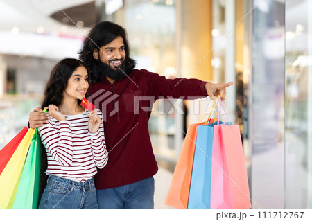 Excited eastern couple shopping together at mall Excited eastern couple shopping together at mall 111712767