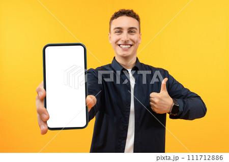 Handsome Excited Man Showing Smartphone With White Empty Screen Handsome Excited Man Showing Smartphone With White Empty Screen 111712886