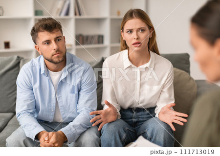 Husband and wife engage in marital counseling in therapist's office Husband and wife engage in marital counseling in therapist's office 111713019