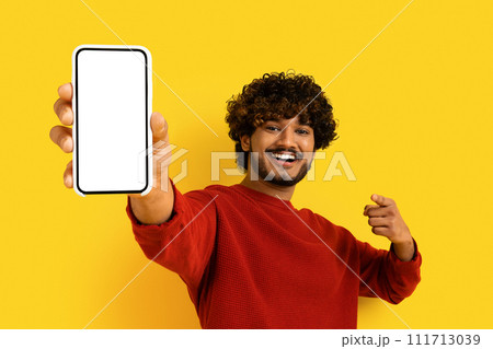 Positive eastern man showing smartphone with blank screen Positive eastern man showing smartphone with blank screen 111713039