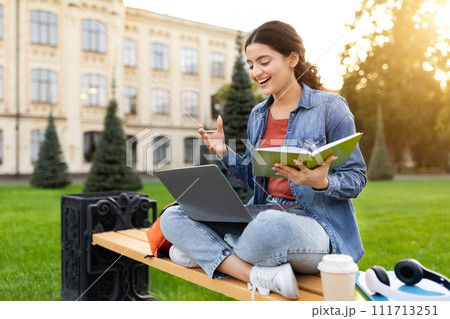 Young indian woman student have online class, sitting on bench 111713251