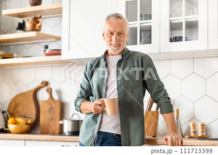 Smiling Senior Man Drinking Coffee In Kitchen Interior Smiling Senior Man Drinking Coffee In Kitchen Interior 111713399
