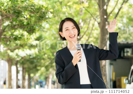 屋外でマイクを持つ女性アナウンサー 111714052