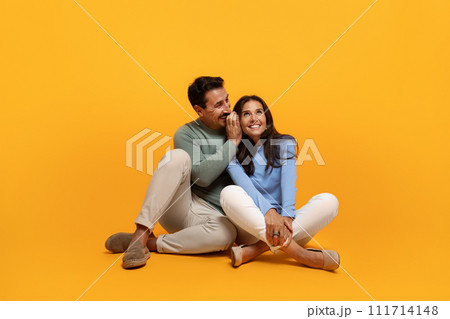 Smiling old caucasian husband whispers in ear to wife, enjoy free time 111714148