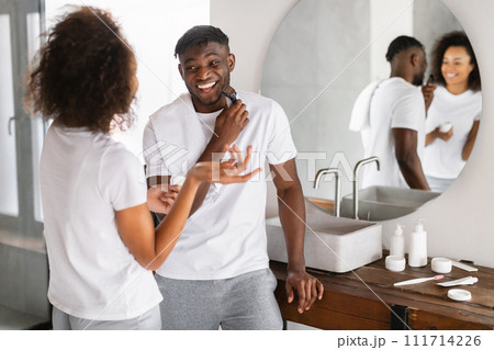 black couple talking and laughing while husband shaving in bathroom black couple talking and laughing while husband shaving in bathroom 111714226