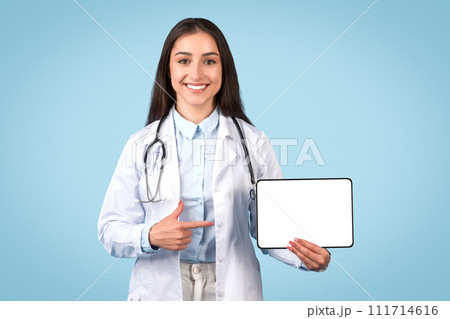 Happy female doctor presenting digital tablet with blank screen 111714616