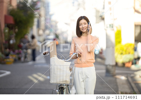 自転車で買い物に行くミドルの女性 111714691