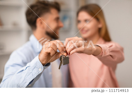 Millennial European couple hugging showing keys to new apartment indoor Millennial European couple hugging showing keys to new apartment indoor 111714913