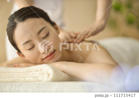 エステサロンでマッサージを受ける若い女性 111715417