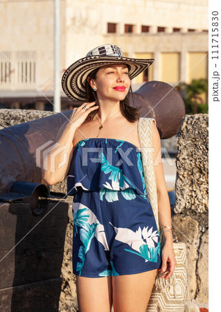 Beautiful woman wearing the traditional Colombian hat called Sombrero Vueltiao at San Ignacio Bulwark in the historical Cartagena de Indias walled city 111715830