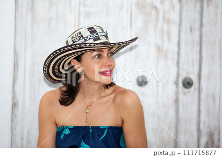 Beautiful woman wearing the traditional Colombian hat called Sombrero Vueltiao at the historical streets of the Cartagena de Indias walled city 111715877